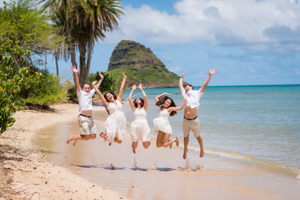 A group of friends taking a jumpshot picture on a sunny day at the beach captured by oahu hawaii photography