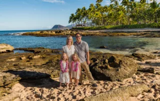 an image of a family of 4 all smiling with the beach as their background captured by koolina photographer