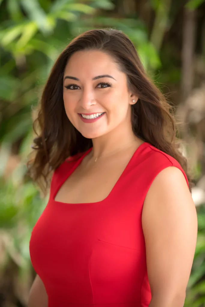 An image of a woman dressed in red smiling in front of a camera taken by oahu photographers