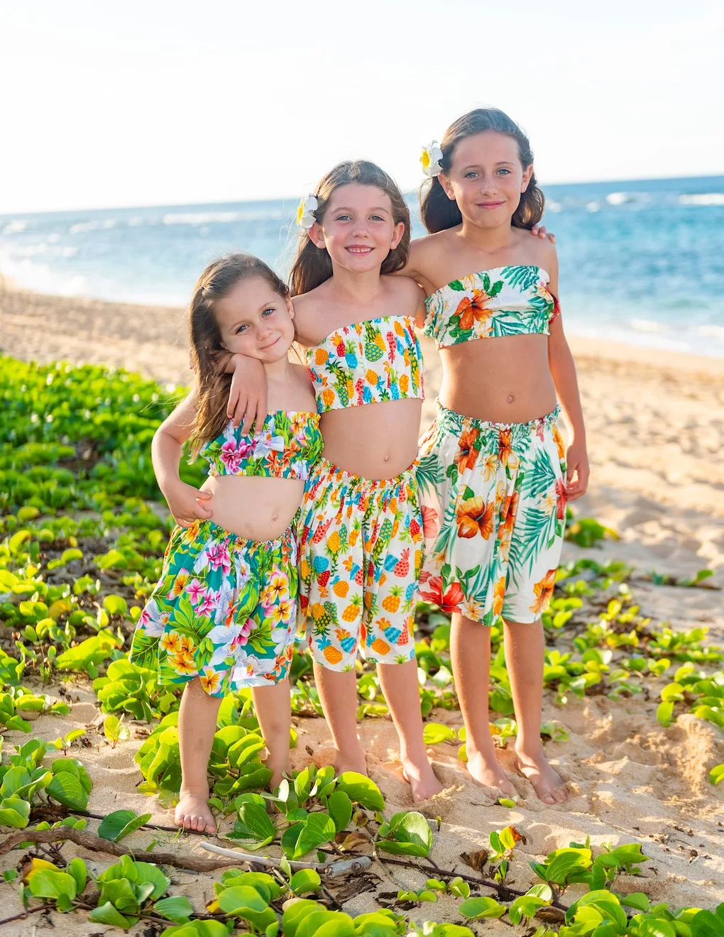 A photo of 3 siblings on a beach side by oahu hawaii photographer