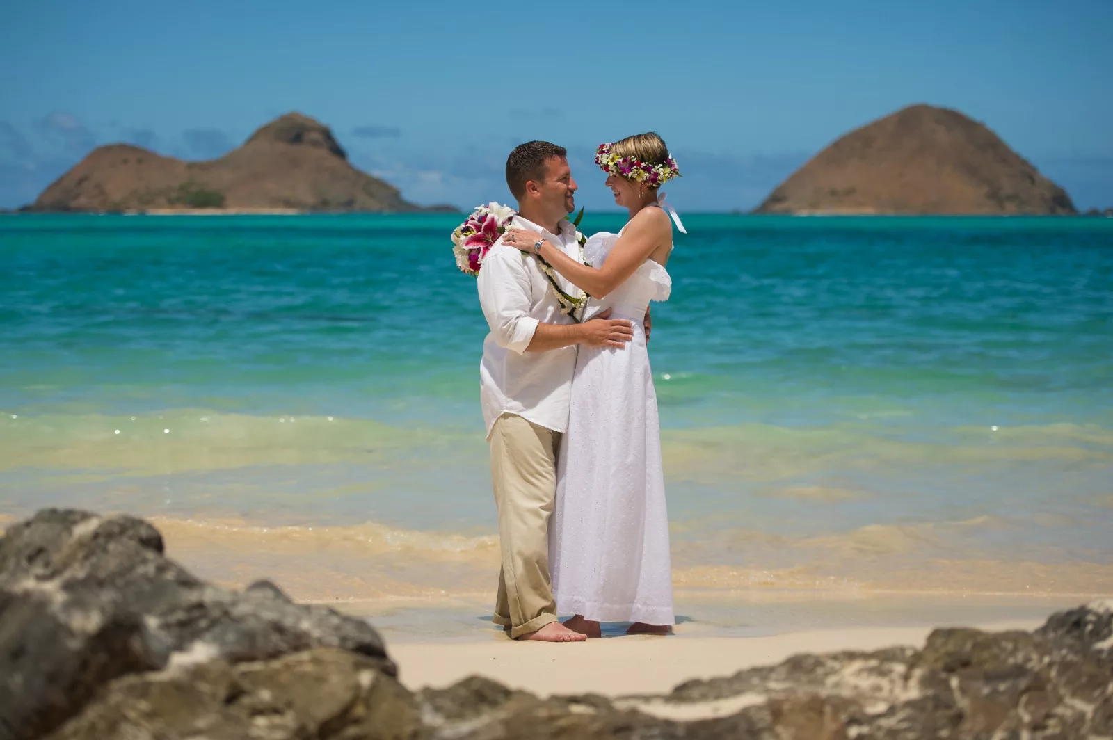an image of a man and woman in the beach facing and holding each other taken by oahu hawaii photographer