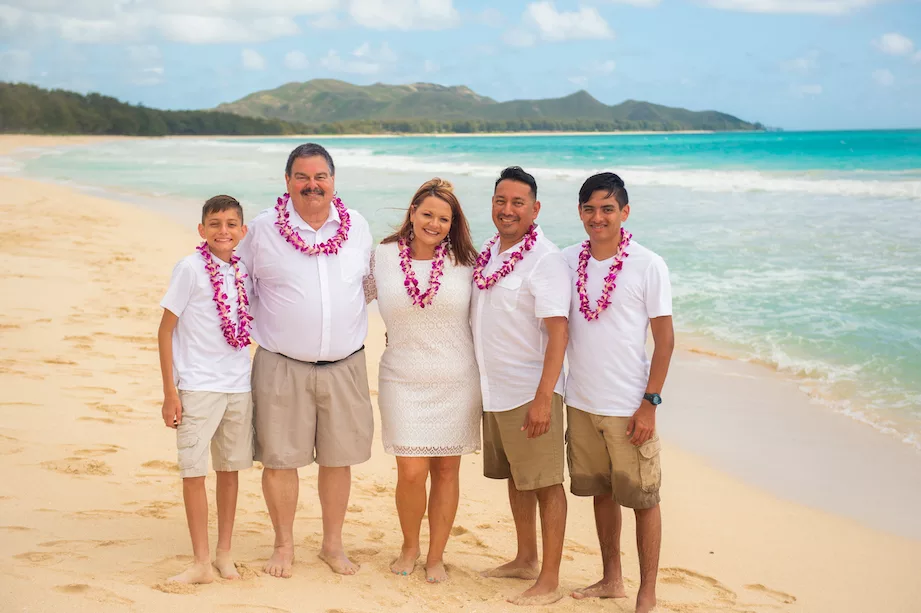 an image of a family wearing a lei around their neck at the beach taken by oahu hawaii photographer