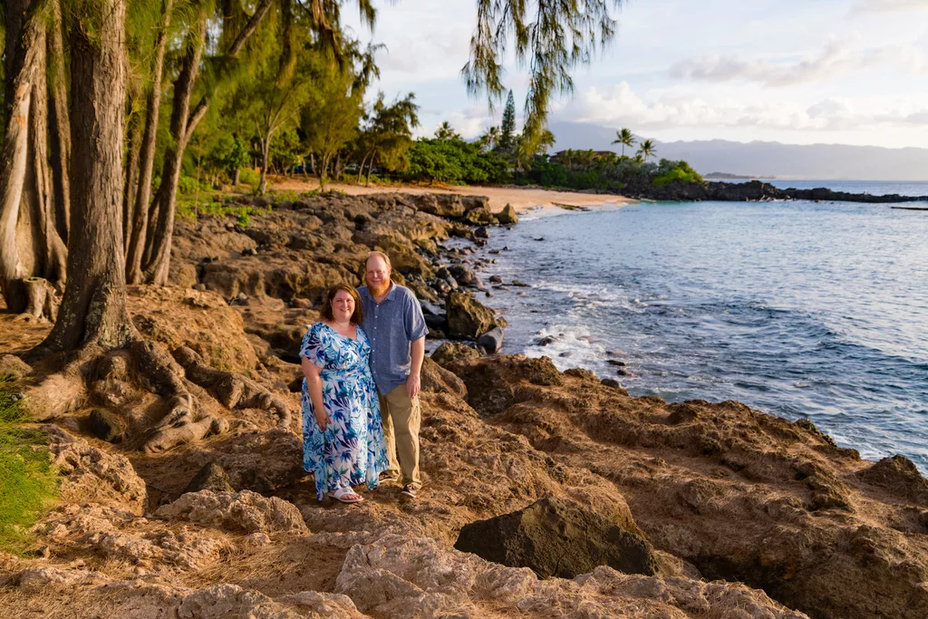an image of a couple standing on the beach smiling at a oahu photographer